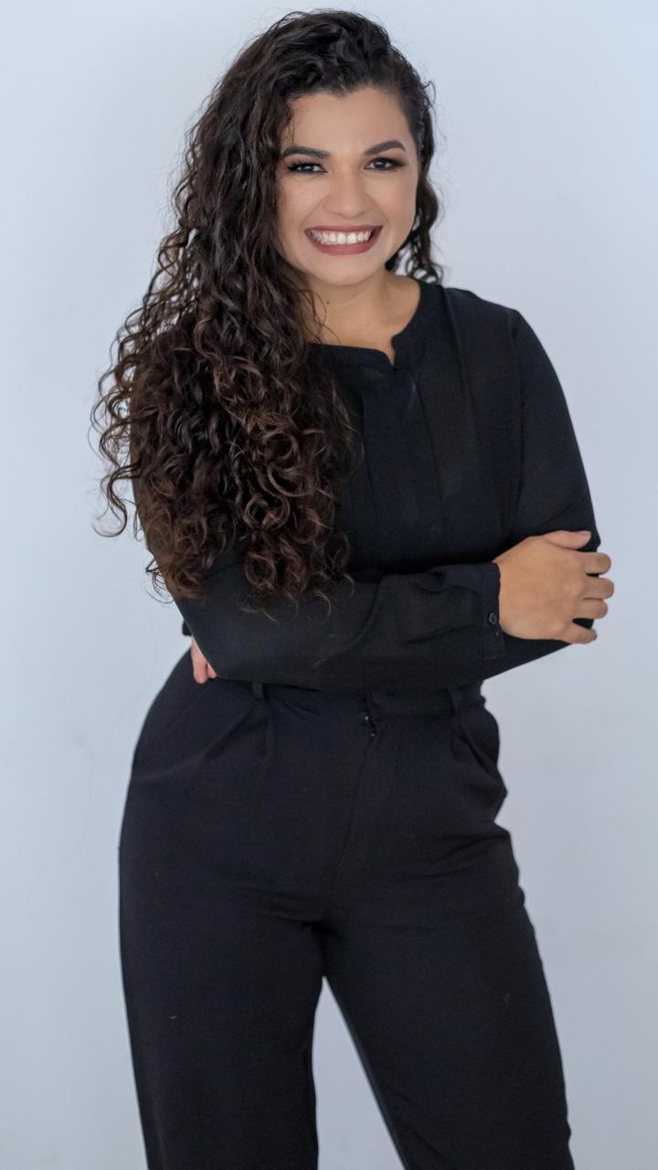 Geisy Fernandes de corpo inteiro, de braços cruzados
